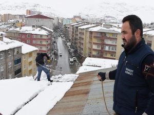 Ekmeklerini çatıdan temizledikleri kardan çıkarıyorlar